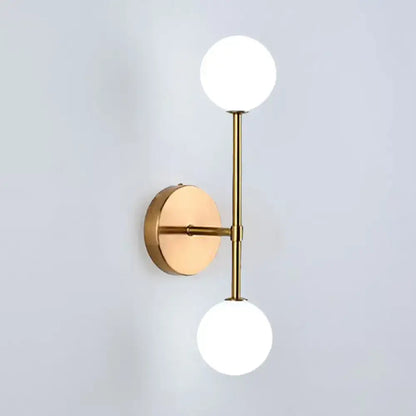 Contemporary black and gold wall lamp with modern brass dual ball design and two frosted glass globe shades inch fixture