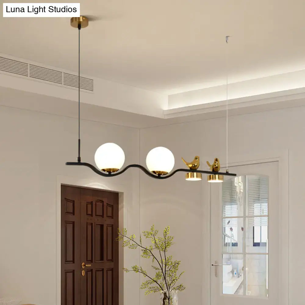 DecorBites™ modern black metal linear branch dining pendant with cream glass globes and gold bird figurines for dining room island