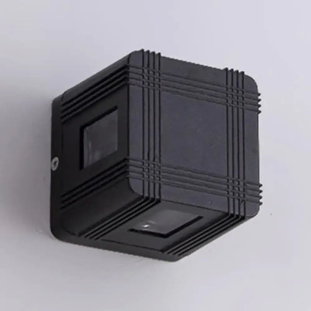 Contemporary black aluminum cubic wall-mounted solar lantern with ribbed texture and white warm lighting