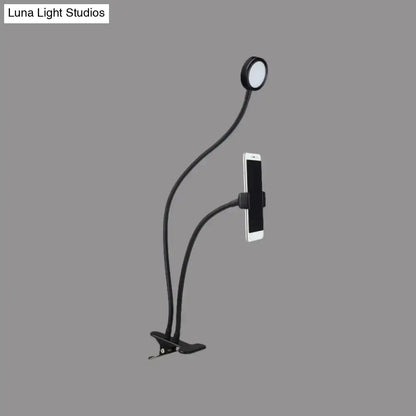 Contemporary black flexible led desk lamp with gooseneck phone clip and circular light head for bedroom use
