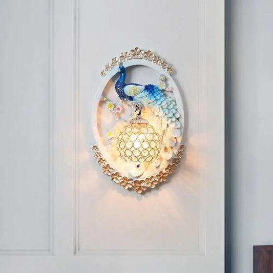 Contemporary blue and white peacock wall sconce with gold floral accents and crystal ball for living room living space