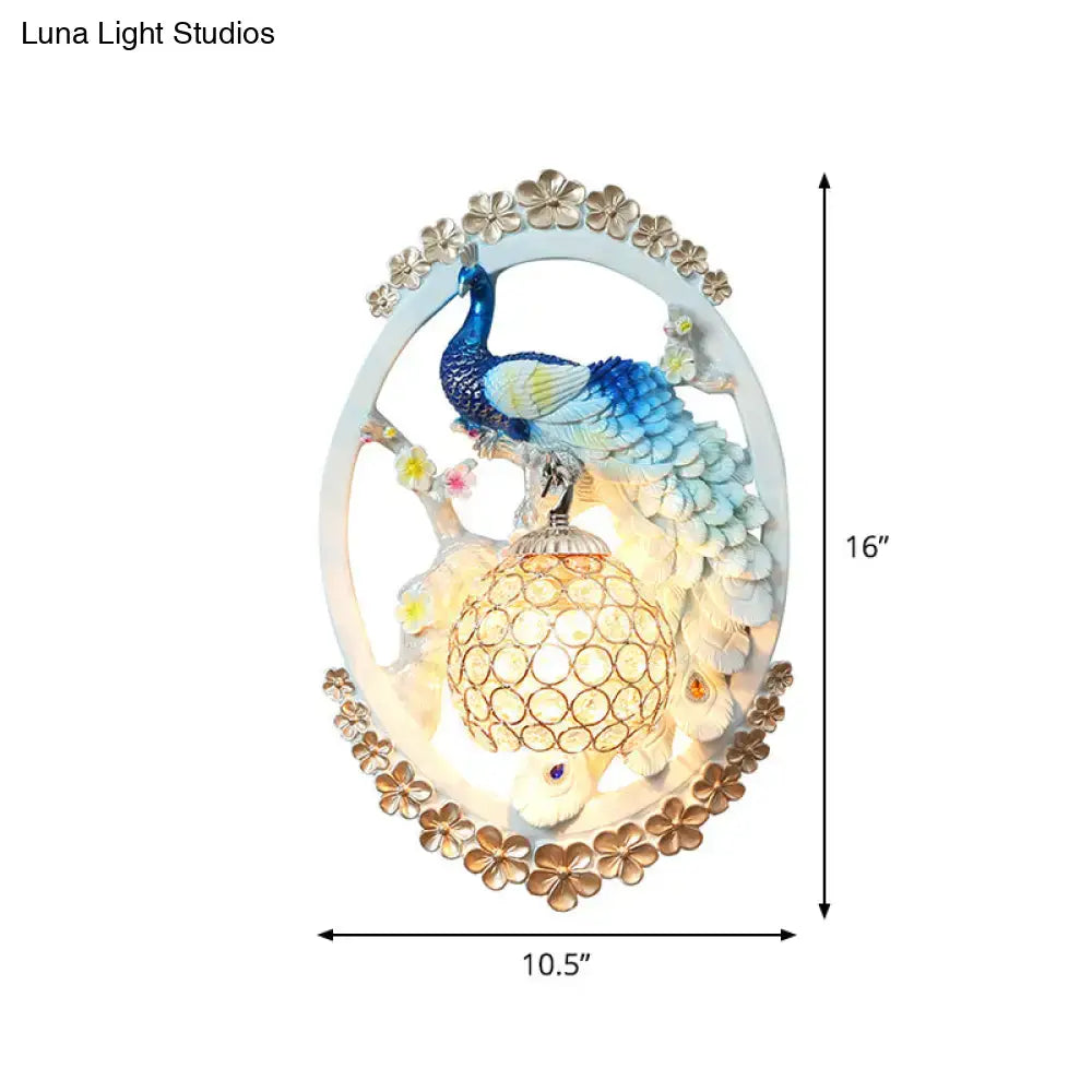 Contemporary wall sconce with blue and green peacock perched on crystal ball with gold accents for living room living space