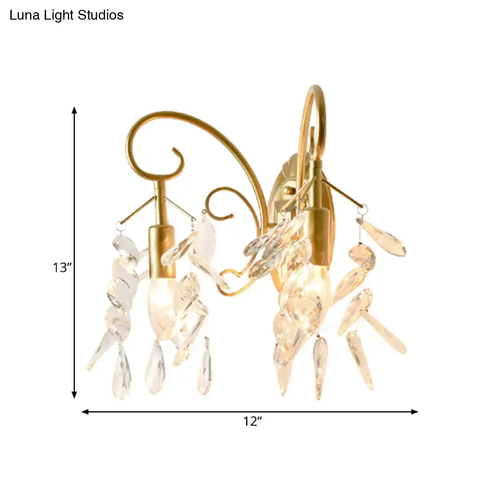 Contemporary gold-toned brass teardrop crystal wall mount light with two ornate arms for bedroom use