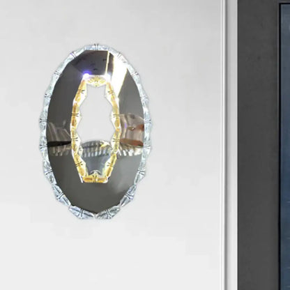 Contemporary silver-framed oval light fixture with decorative beaded edge and warm white crystal interior design mirror
