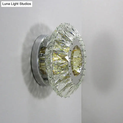 Contemporary chrome wall lamp with round faceted crystal design and polished chrome base for bedroom lighting
