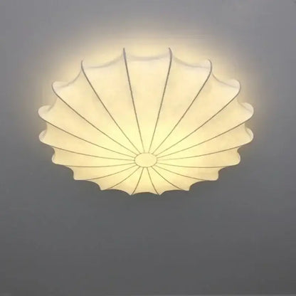 Contemporary cream petal led ceiling light with scalloped fabric design and black ribs for dining room use