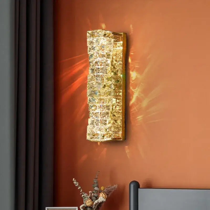 Contemporary crystal wall sconce with embedded cubes in a gold-toned frame for bedroom decorbites wall sconce