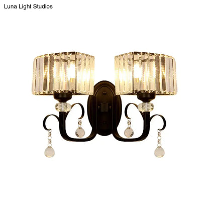 Elegant black wrought iron metal wall sconce with two crystal-encased teardrop fixtures for bedroom wall lamp lighting