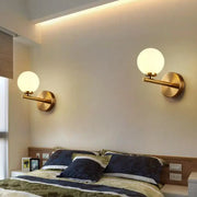 Contemporary gold-toned wall light fixture with frosted white glass globe shades e12 suitable for bedroom use