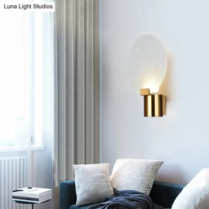 Contemporary gold wall lamp with bubble glass textured frosted oval shade ideal as a bedroom sconce