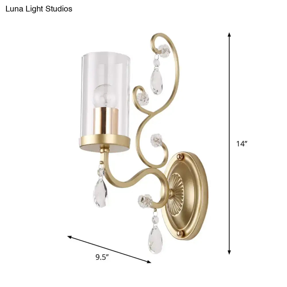 Contemporary gold wall light with clear glass cylindrical shade and crystal teardrop accents for bedroom use