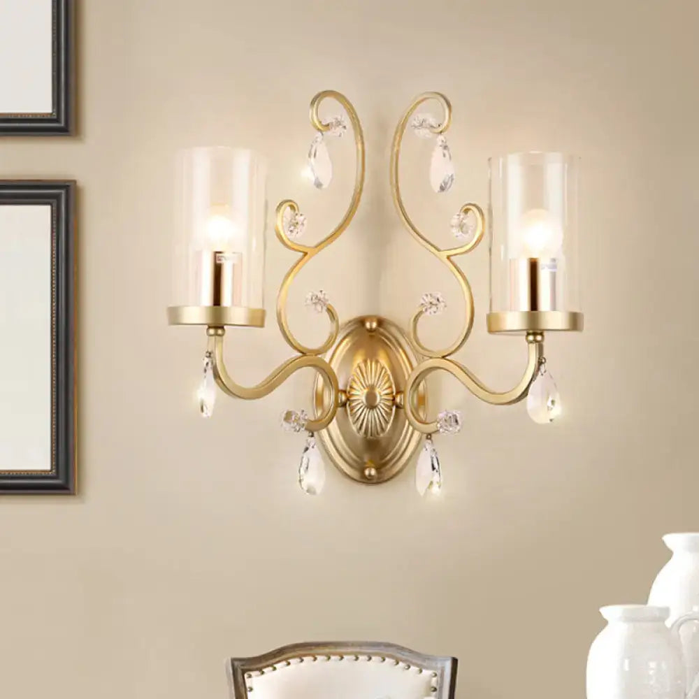 Contemporary gold wall light with clear glass shades and crystal droplets designed as an ornate glass wall sconce