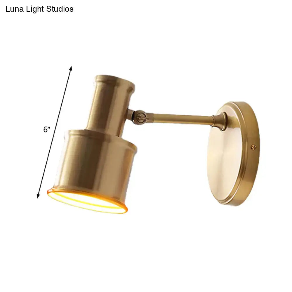 Contemporary brass-finished metal cylinder wall sconce with adjustable cylindrical shade and 6-inch length for bedroom reading