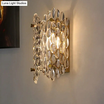 Contemporary gold metal wall light with clear crystal faceted discs in an overlapping pattern for hallway use