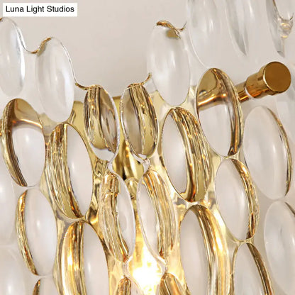 Contemporary gold metal wall light with clear crystal oval glass elements in a cascading design for hallway use