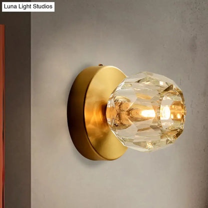 Contemporary golden wall mount lamp featuring a faceted crystal glass shade for elegant living room lighting