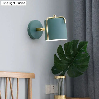 Contemporary green grey cylindrical wall sconce with brass accents designed for bedroom lighting