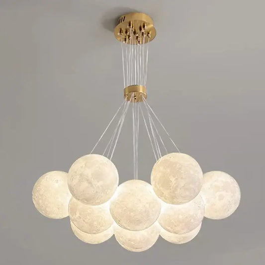 A gold modern ceiling chandelier with textured moon-like spherical pendant lights decorbites contemporary led decor