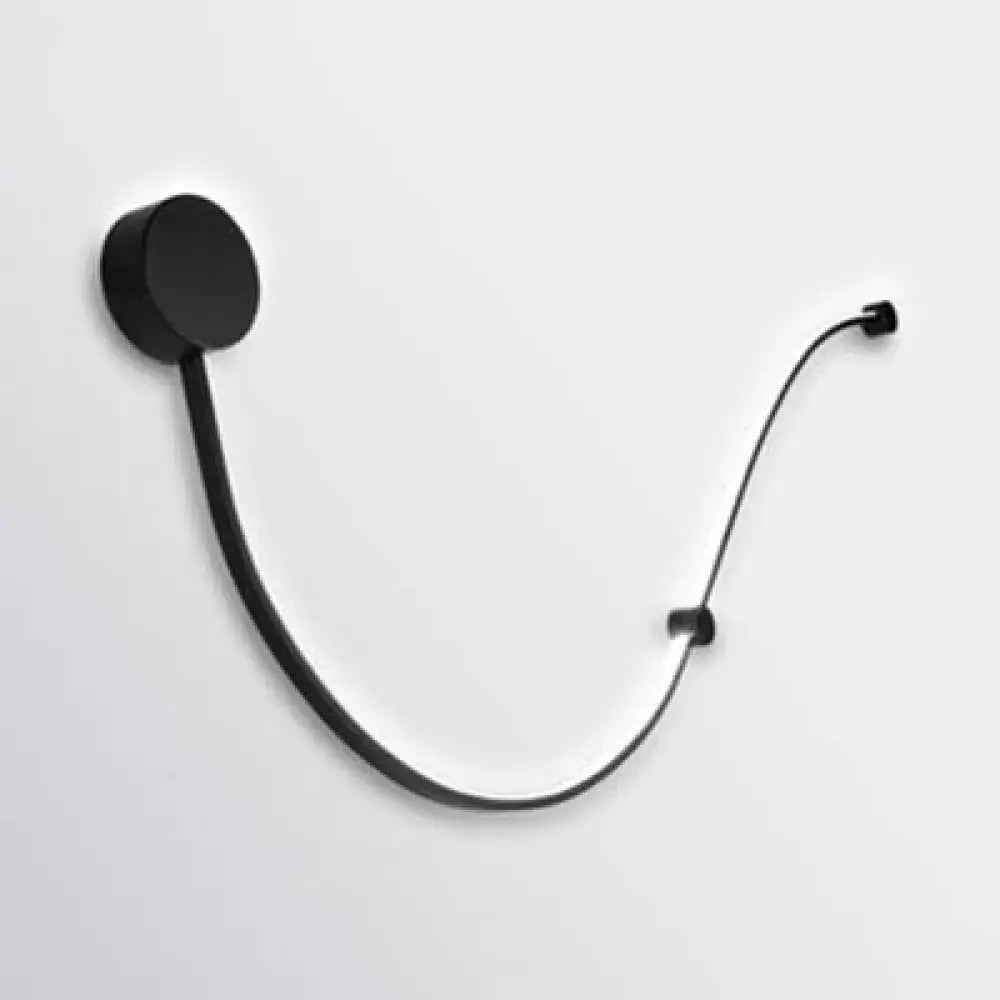 Black minimalist wall-mounted headphone stand with sleek curved design and contemporary twist wall sconce white warm light