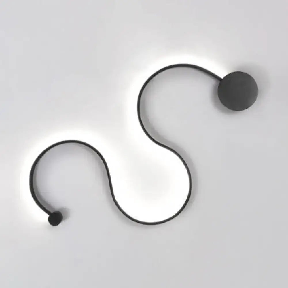 Contemporary twist black wall sconce with sleek s-shaped design and warm white light for bedroom use