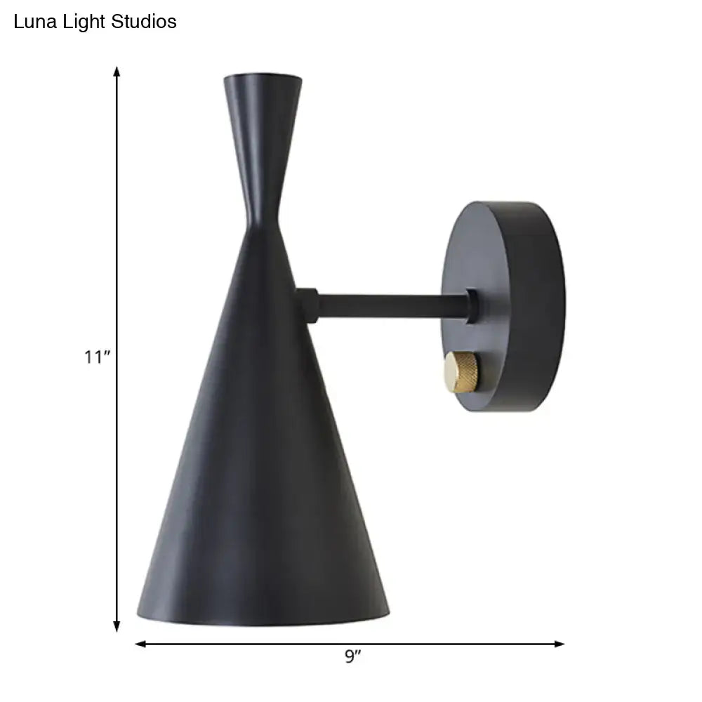 Black matte wall sconce with adjustable arm, sleek conical shade, and brass accent knob for contemporary bedroom lighting