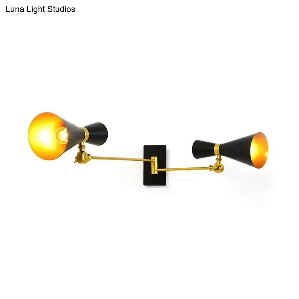 Contemporary white and gold adjustable arm wall sconce with black and brass double arms emitting warm glow