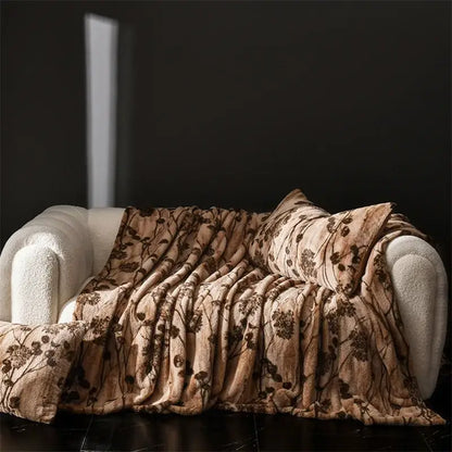 A cosy faux rabbit plush beige throw blanket with dark brown floral pattern draped over white couch decorbites cosy faux
