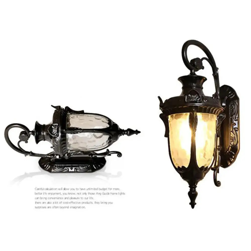 Country black wrought iron outdoor wall lantern with ornate detailing and warm amber-tinted glass panel for outdoor wall use