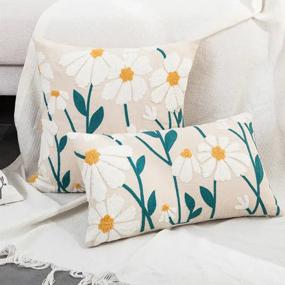 Cream-colored rectangular cushion cover with floral embroidered white daisies and teal stems for living room decor
