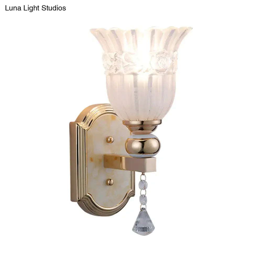 Elegant gold finish glass floral wall sconce with frosted glass floral shade and crystal teardrop pendant for bedroom lighting