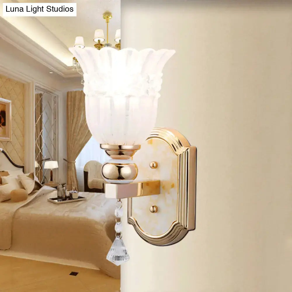 Gold finish country wall sconce with frosted glass floral shade and crystal droplet accent for bedroom lighting