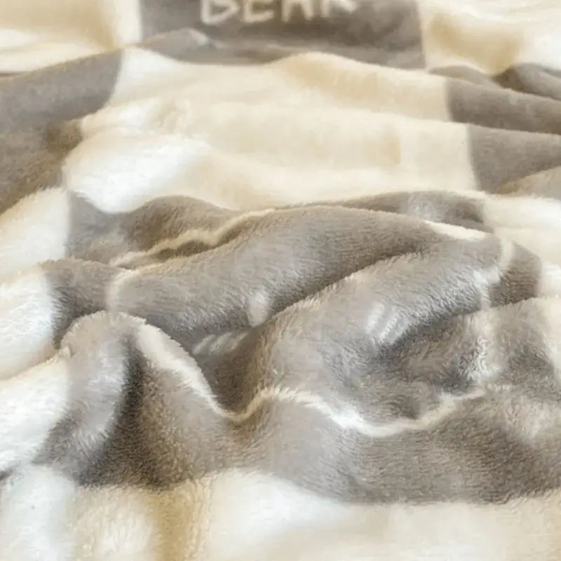 A soft plush gray and cream checkered fleece blanket from decorbites cozy checkered collection for bear bedroom throw