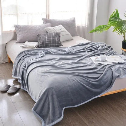 Soft gray decorbites cozy checkered fleece blanket with subtle sheen and finished edges draped over bed