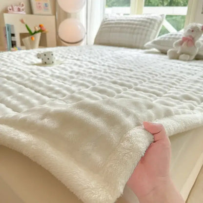 Cream-colored plush quilted mattress pad with cozy faux rabbit fur texture and raised diamond-patterned stitching decorbites cozy faux