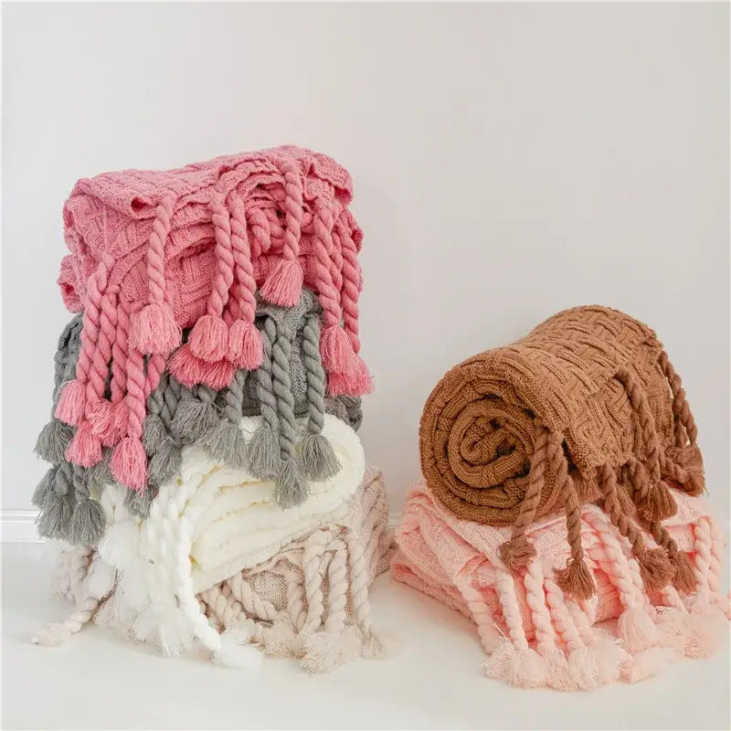 Stack of decorbites cozy fringed plaid chunky knit throw blankets in pink gray white and beige with braided tassels for bedroom decor