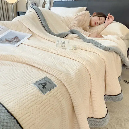 Cream-colored decorbites cozy jacquard plush blanket with textured quilted pattern and gray fleece trim edges
