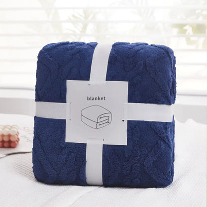 Deep blue plush blanket with textured raised pattern wrapped in white ribbon from decorbites cozy jacquard plush collection