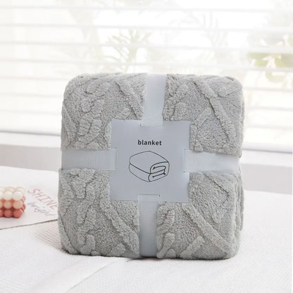 A soft light gray decorbites cozy jacquard plush blanket with textured pattern wrapped in white ribbon for sofa decor