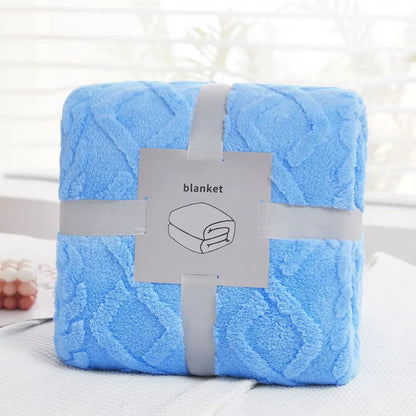 A soft light blue decorbites cozy jacquard plush blanket with textured diamond pattern wrapped in gray ribbon