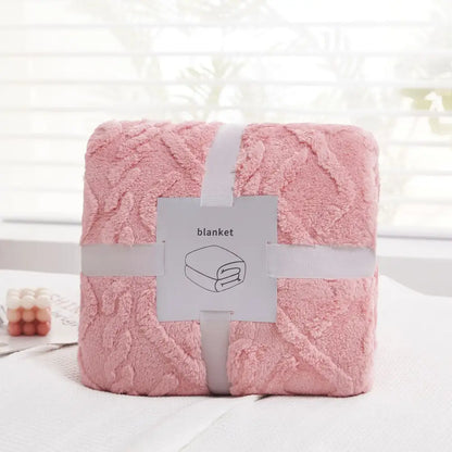 A soft pink plush blanket with a textured looped surface neatly wrapped in white ribbon from decorbites cozy jacquard