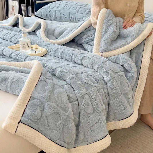 A cozy jacquard taffeta light blue plush flannel nap blanket with a cream fleece border and quilted pattern for bedroom decor
