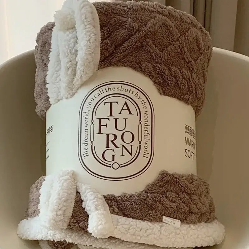 Cozy brown and white coral fleece blanket with soft textured surface and fluffy ear-like trim for bedroom use
