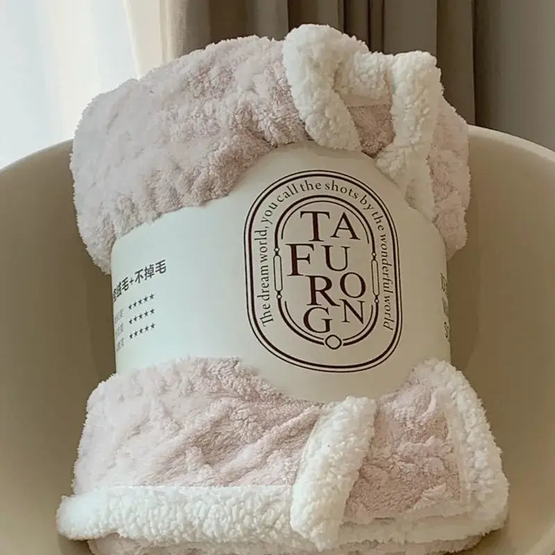A soft plush pink and white coral fleece blanket with a cozy textured surface perfect as a sherpa throw