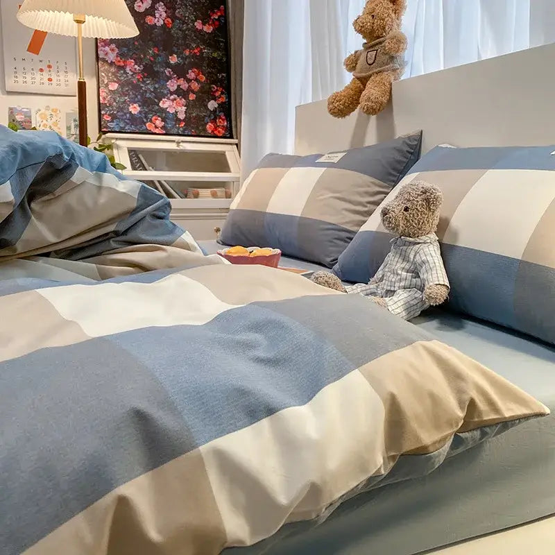 Blue beige and white striped cozy plaid duvet cover set with plush teddy bear in matching pajamas on bed decorbites cozy plaid