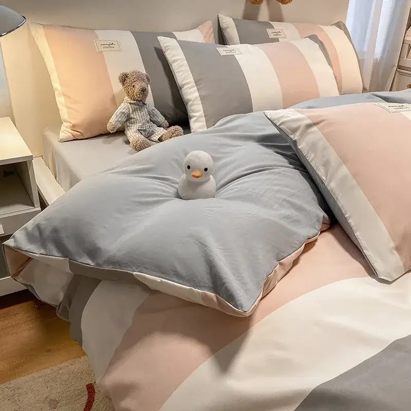 Soft gray and blush pink striped bedding set with plush white duck toy on decorbites cozy plaid duvet cover