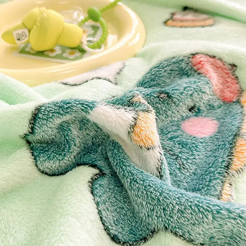 Soft mint-green plush blanket with cute cartoon elephant and colorful flower patterns for cozy bedroom decor