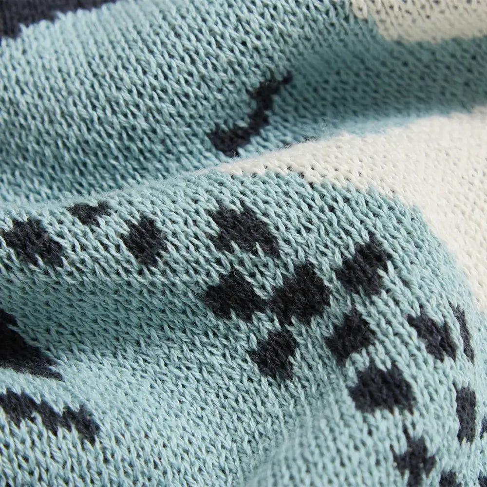 A soft light blue knitted scarf with dark gray diamond motifs complements the decorbites cute sea horse cotton blanket decor