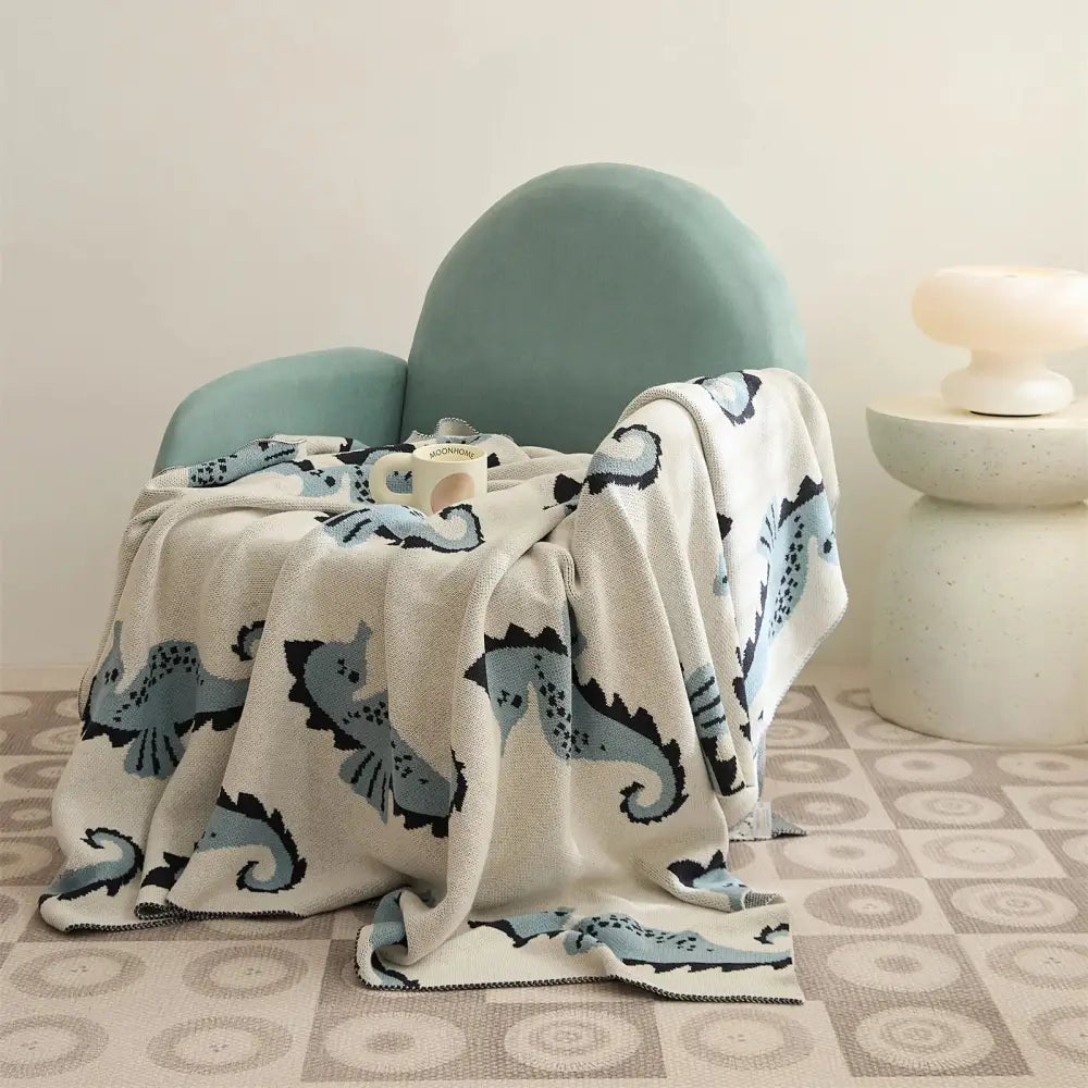 Cream and blue cute sea horse cotton knit throw blanket with soft cream base and playful sea horse pattern