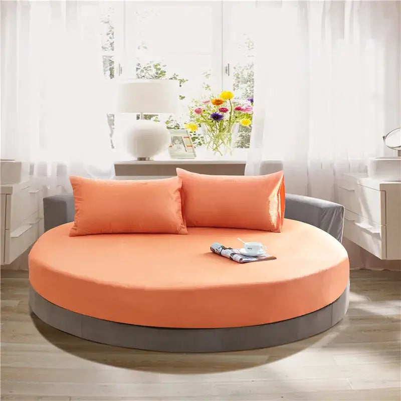 Round daybed with orange upholstered seat and gray base frame paired with cream and gray fitted bed sheet set