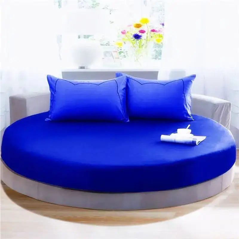Vibrant royal blue round fitted bed with matching pillowcases and a sleek gray base in cream and gray bedroom decor